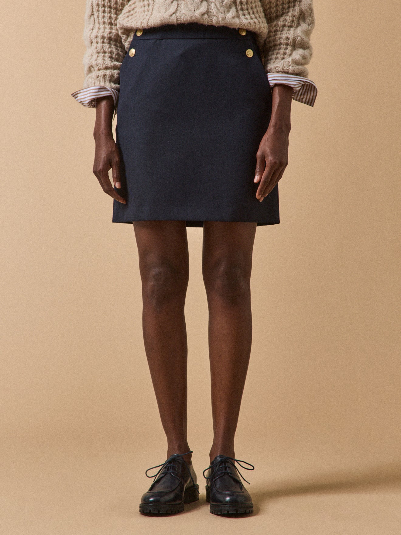 Kurzer Damenrock mit goldfarbenen Knöpfen